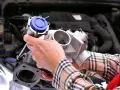 Mechanik pokazuje turbosprężarkę, element silnika, gdzie znajduje się czujnik ciśnienia doładowania.
