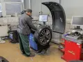 Mechanik sprawdza na maszynie, ile kosztuje wyważenie kół. Na ekranie widoczny jest schemat felgi.