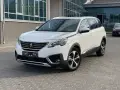 Biały Peugeot 5008 na parkingu. Wiele osób szuka peugeot 5008 opinie, ten SUV to świetny wybór.