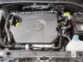Silnik 1.4 z Fiata Grande Punto. Widoczny plastikowy kolektor, akumulator i zbiornik płynu chłodniczego.
