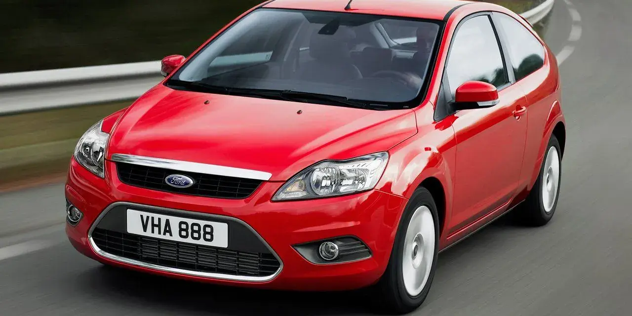 Czerwony Ford Focus MK2 1.6 benzyna w ruchu na krętej drodze.