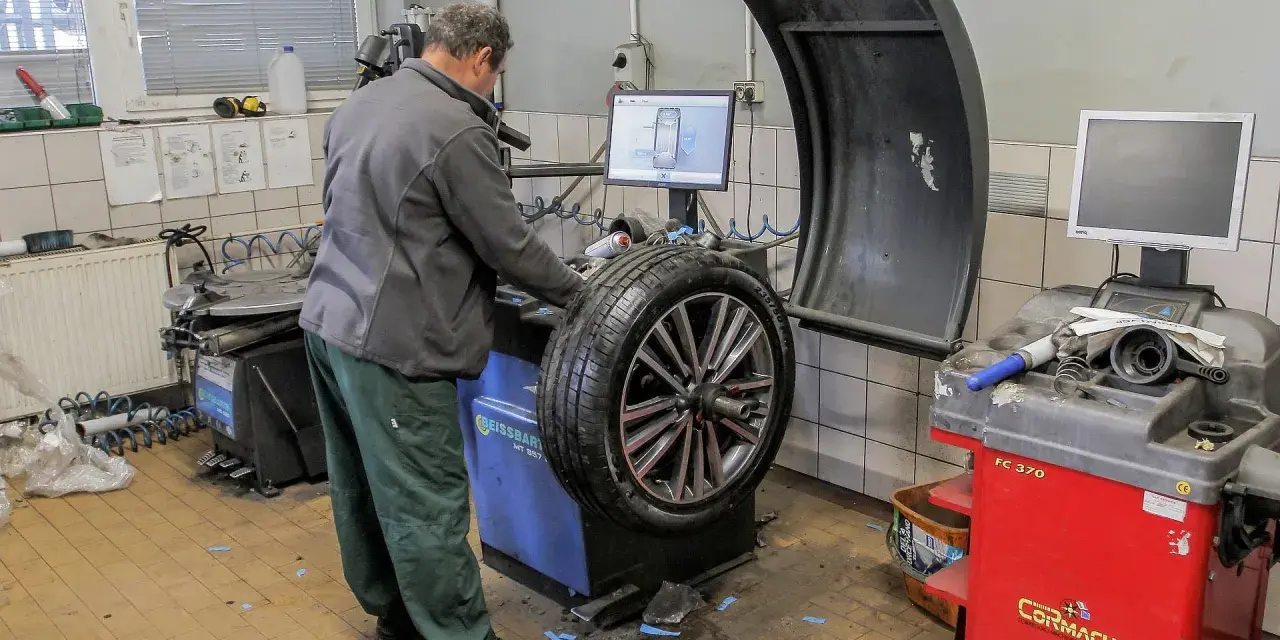 Mechanik sprawdza na maszynie, ile kosztuje wyważenie kół. Na ekranie widoczny jest schemat felgi.