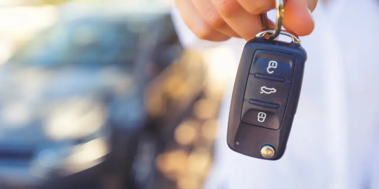 Dłoń trzyma kluczyk samochodowy. Gdyby wystąpiły uszkodzony immobilizer objawy, auto mogłoby nie odpalić.
