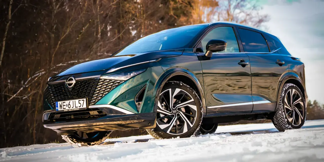 Zielony Nissan Qashqai na śniegu. Wiele osób szuka nissan qashqai opinie, by sprawdzić, jak radzi sobie w trudnych warunkach.