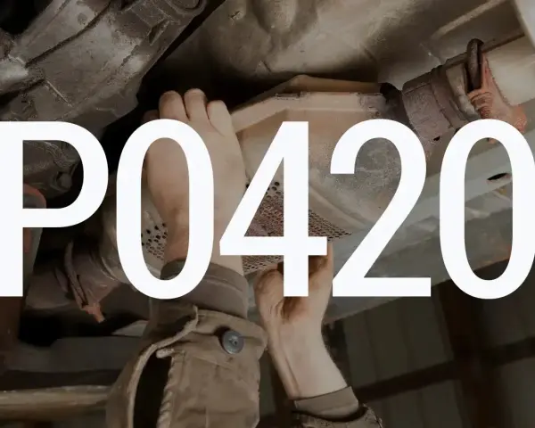 Mechanik sprawdza katalizator Peugeota z powodu błędu DTC P0420.