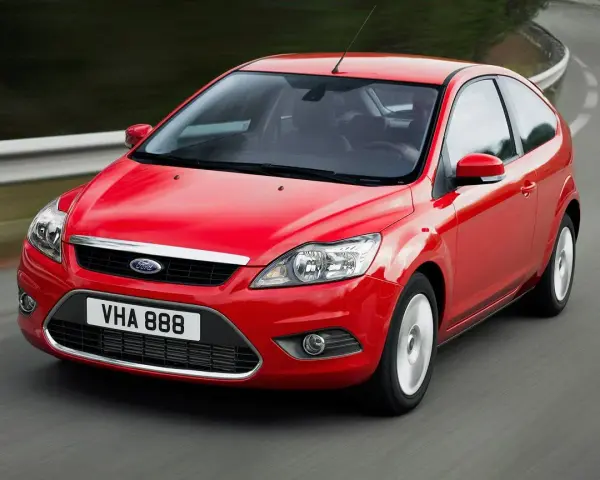 Czerwony Ford Focus MK2 1.6 benzyna w ruchu na krętej drodze.