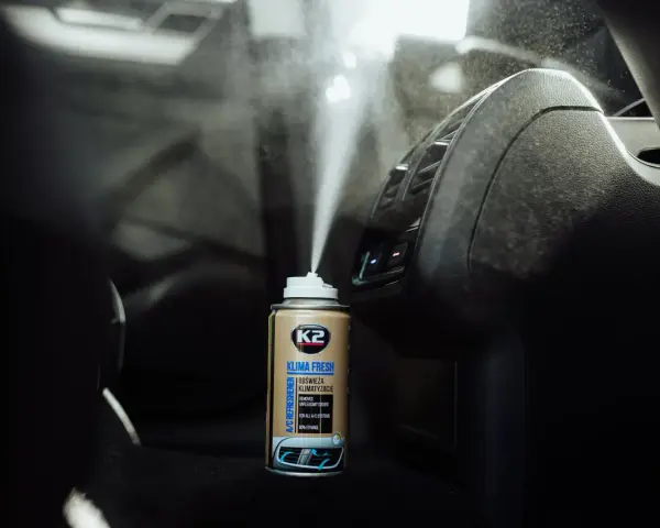 Pryskanie preparatem K2 Klima Fresh do dezynfekcji klimatyzacji samochodowej. Mgła rozpyla się w kierunku nawiewów.