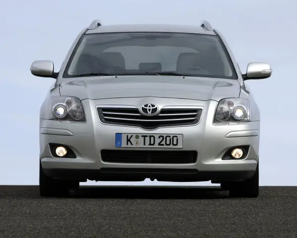 Srebrny Toyota Avensis T25 z włączonymi światłami mijania i przeciwmgielnymi, gotowy do podróży.
