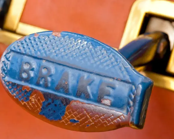 Stary, niebieski uchwyt hamulca z napisem "BRAKE". Zastanawiasz się, jaki smar do prowadnic hamulcowych?