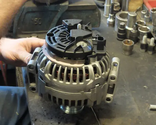 Warsztat samochodowy, gdzie mechanik sprawdza alternator. Zastanawiasz się, ile kosztuje regeneracja alternatora?