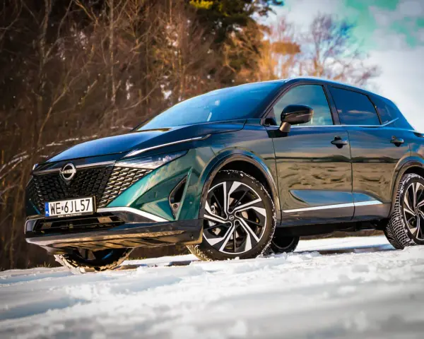 Zielony Nissan Qashqai na śniegu. Wiele osób szuka nissan qashqai opinie, by sprawdzić, jak radzi sobie w trudnych warunkach.