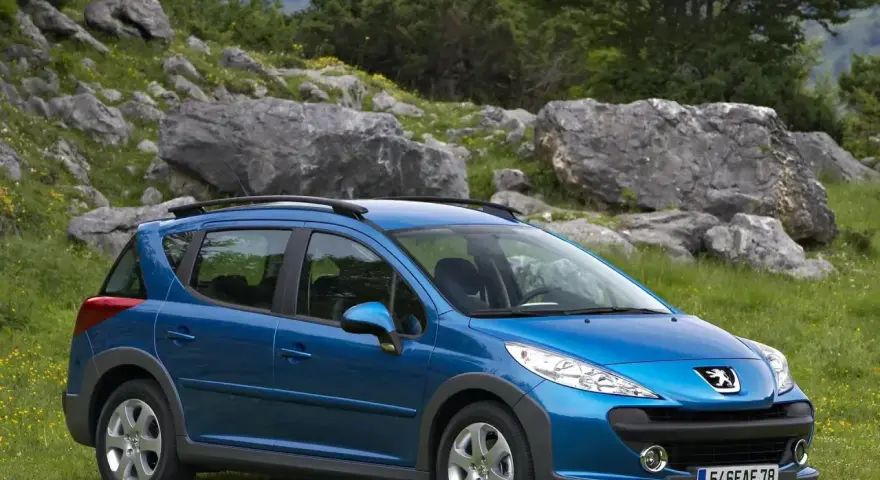 Niebieski Peugeot 207 SW na tle skalistego krajobrazu. Wiele osób szuka peugeot 207 opinie przed zakupem.