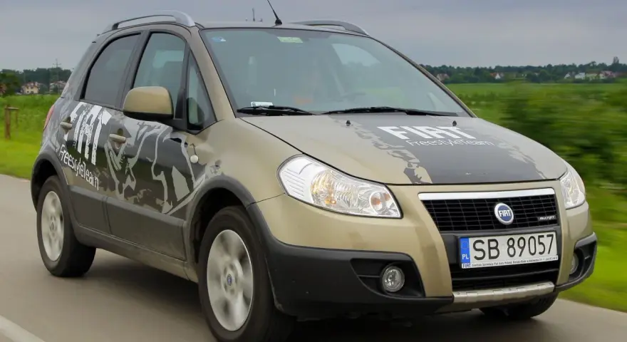 Złoty Fiat Sedici FreestyleTeam w ruchu. Wiele osób szuka opinii o tym modelu.