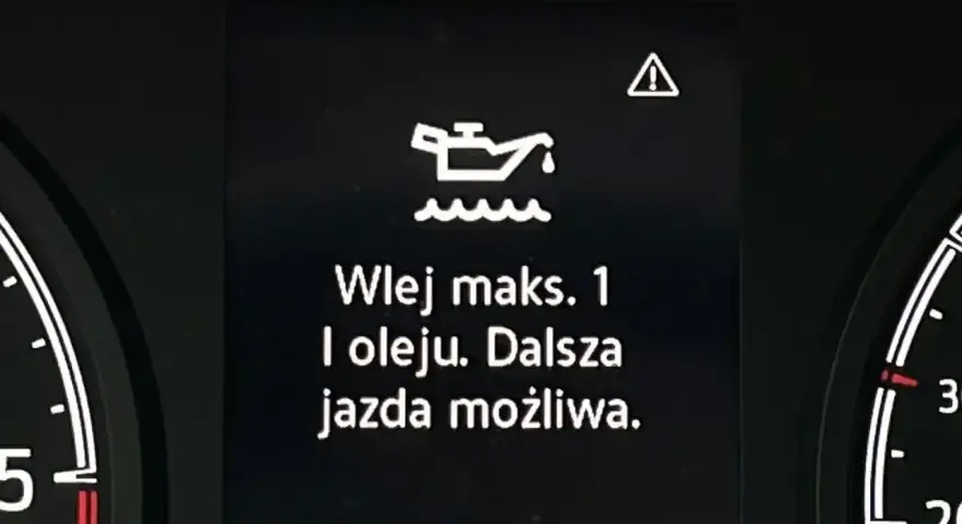 Na desce rozdzielczej migająca kontrolka oleju z komunikatem "Wlej maks. 1 l oleju. Dalsza jazda możliwa." ostrzega o niskim poziomie smarowania.