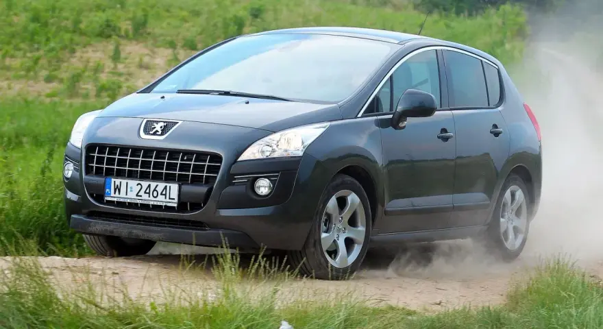 Szary Peugeot 3008 na drodze gruntowej, wzbijający kurz. Wiele osób szuka takich zdjęć, czytając peugeot 3008 opinie forum.