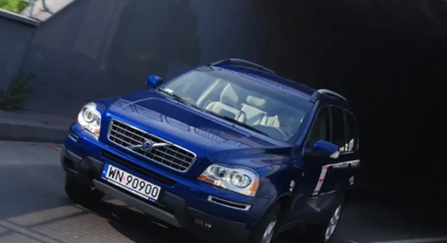 Błękitne Volvo XC90 V8 z jasnym wnętrzem wjeżdża do ciemnego tunelu.